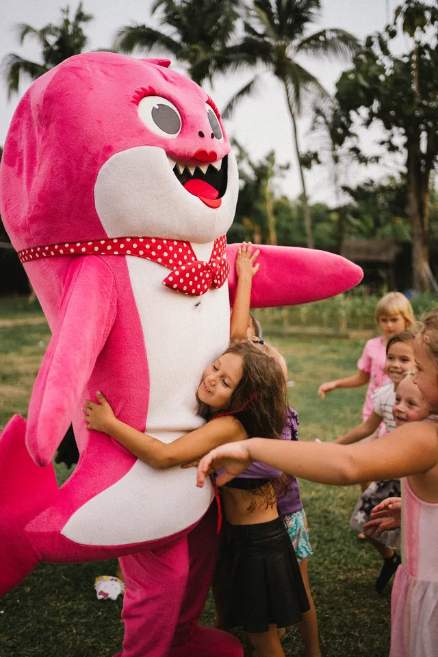 Kids hugging the Baby Shark mascot at a Bali birthday