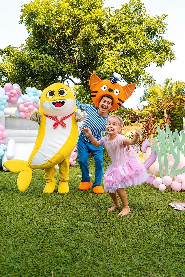 Baby Shark mascot dancing with the birthday girl at a Bali party