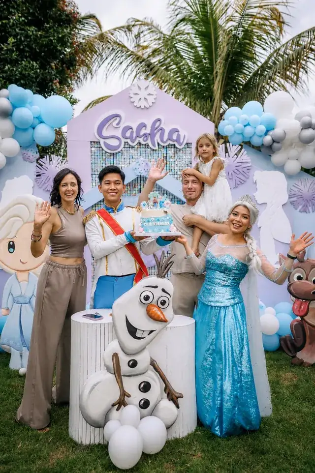 Elsa and Prince characters with a family at a Frozen party in Bali