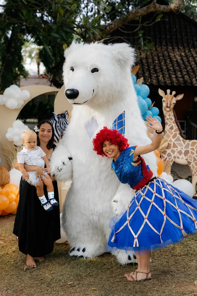 Giant polar bear mascot with a pirate girl and baby at a Bali party