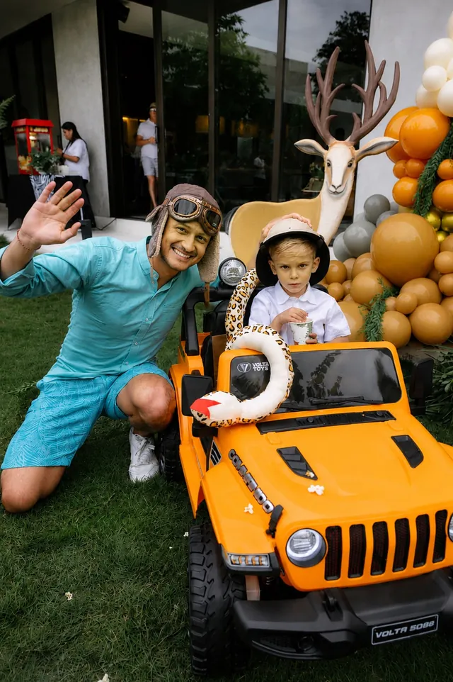 Safari ranger and boy in a toy jeep at a safari-themed party in Bali