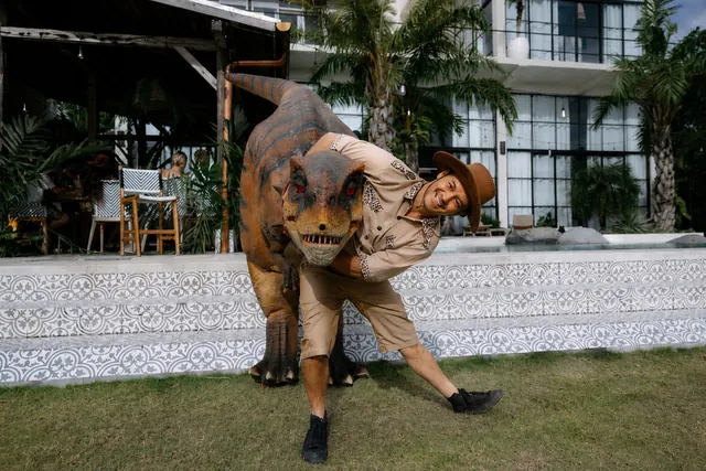 T-rex dinosaur character with a safari ranger at a Bali kids party