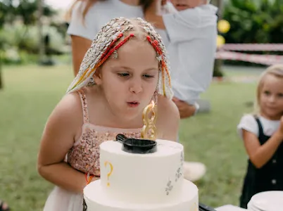 Birthday girl blowing out candles on her cake in Bali