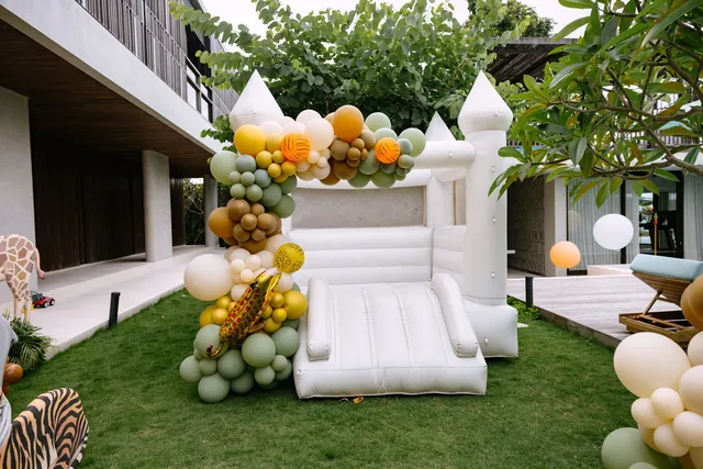 White bounce castle with balloon garland in a Bali villa garden
