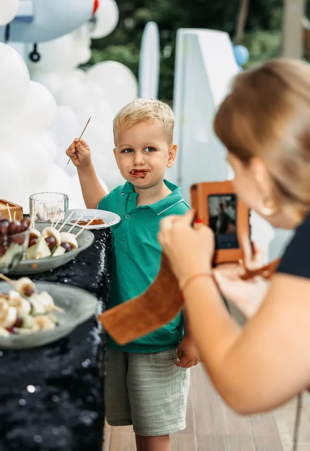 Boy dipping fruit in the chocolate fountain at a Bali party