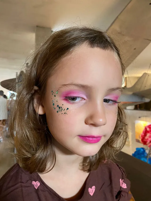 Girl with pink glitter face paint at a kids party in Bali