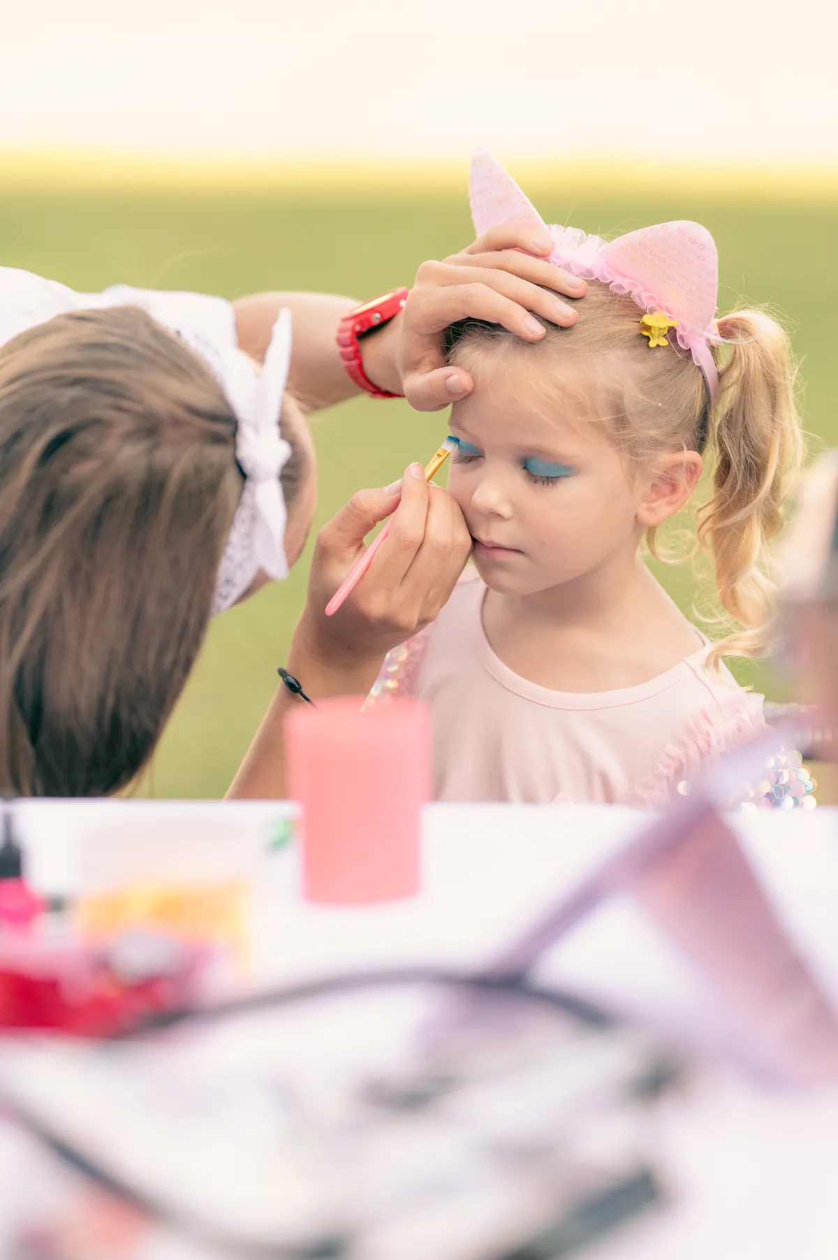 Face painting station at an outdoor kids party in Bali