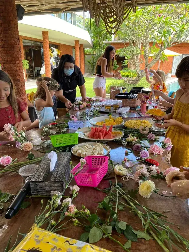 Kids making flower crowns at a workshop table in Bali