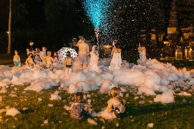 Evening foam party with lights on a Bali villa lawn