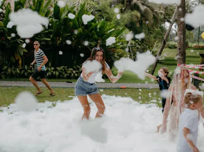 Teenagers playing in party foam at a Bali villa garden