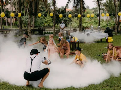 Kids playing in a low fog cloud at a garden party in Bali