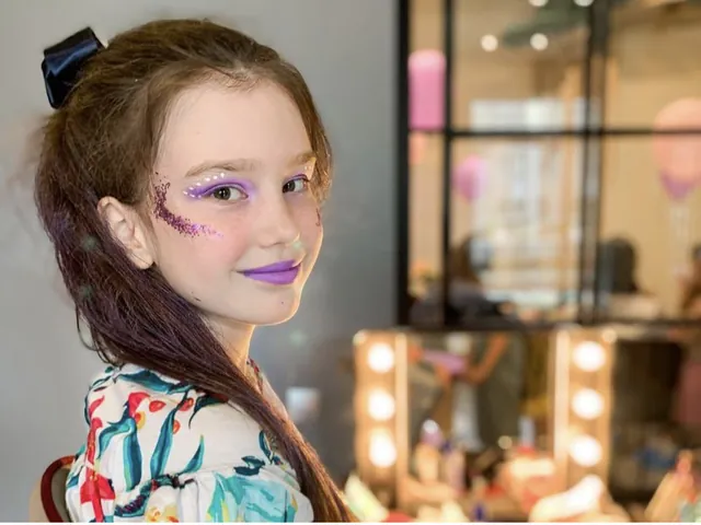 Girl with festive glitter make-up at the kids beauty bar