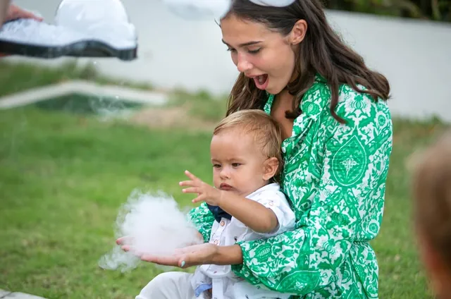 Mum and baby catching nitrogen snow at a first birthday in Bali