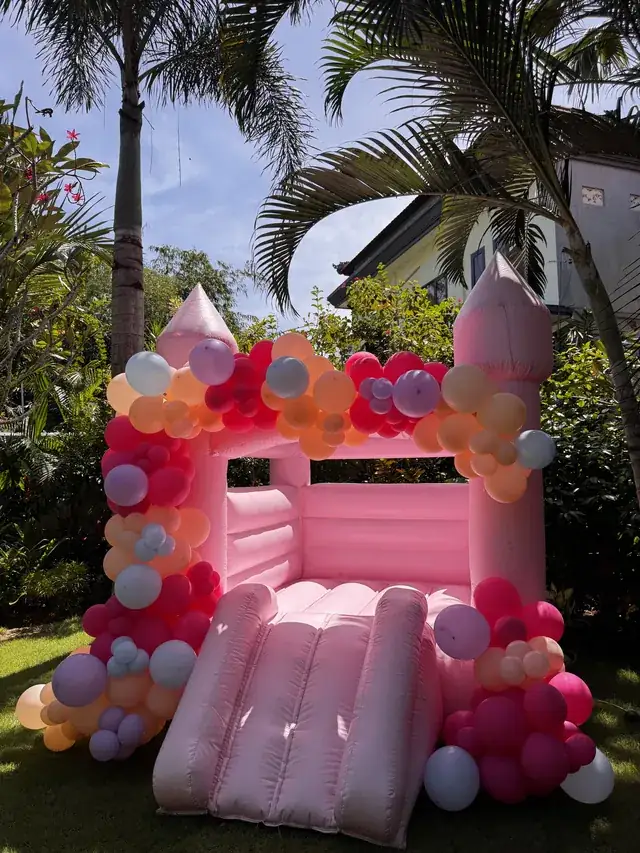 Pink bounce castle with balloon decor at a Bali villa party