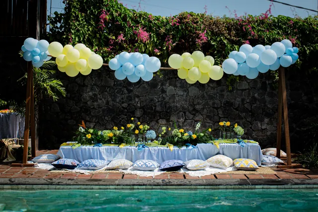 Poolside kids picnic table with balloon clouds at a Bali villa