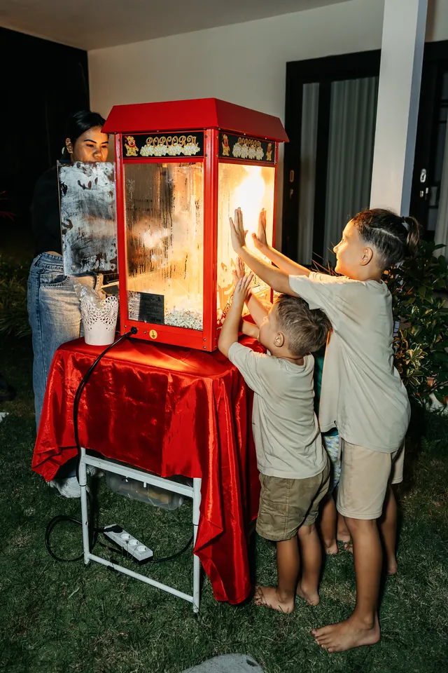 Kids getting fresh popcorn from the machine at a Bali party
