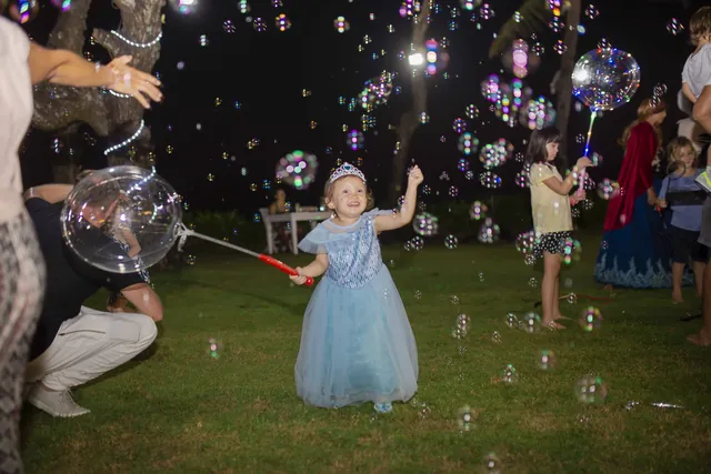 Girl in a princess dress popping giant bubbles at a Bali kids party