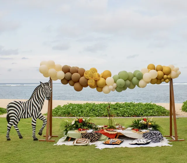 Safari-themed beachfront picnic setup with balloon garland in Bali