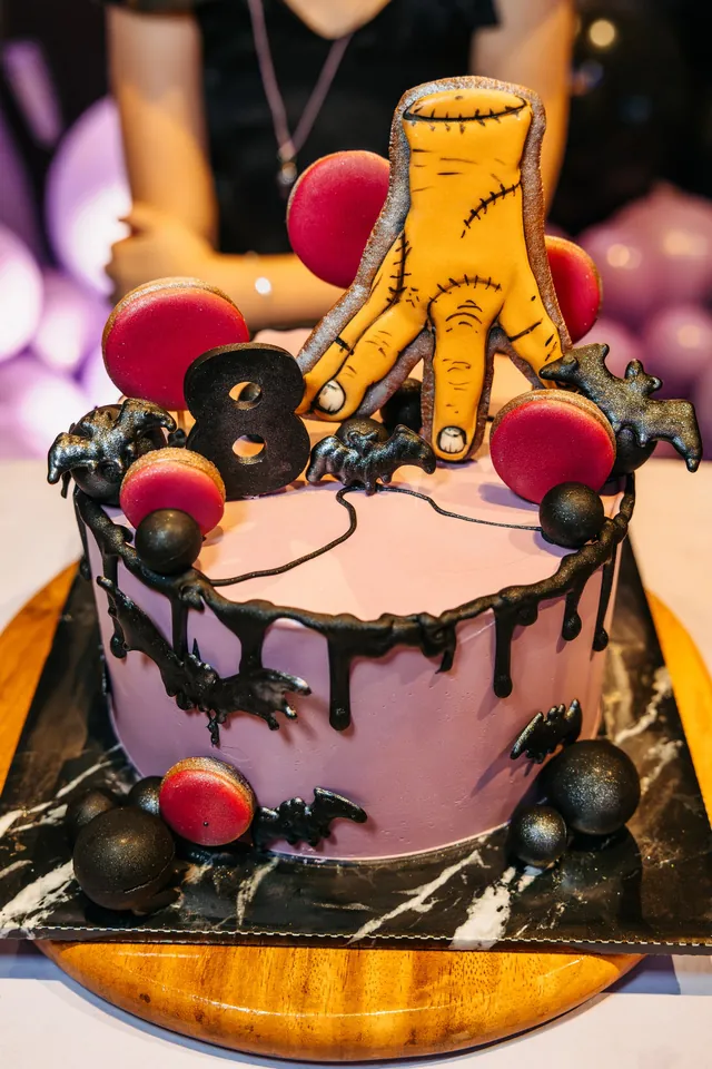 Wednesday-themed birthday cake with the Thing hand topper